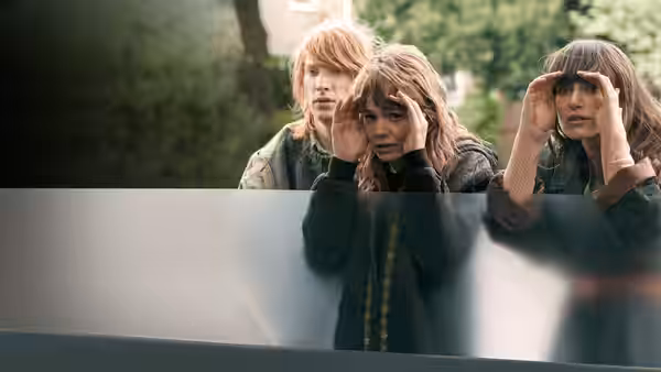 Rodney (Domhnall Gleeson), Kathy (Carey Mulligan) and Ruth (Keira Knightley) peering over a barrier