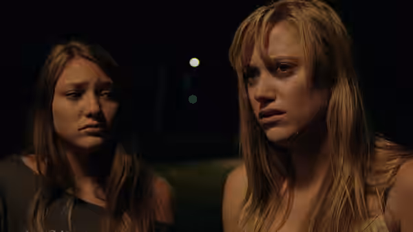 Jay Height (Maika Monroe) standing beside another young woman at night