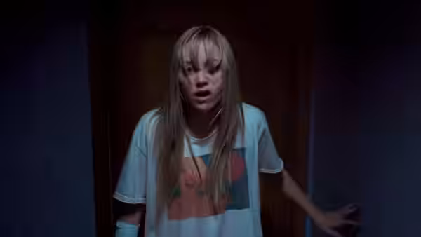 Jay Height (Maika Monroe) standing in a doorway with a startled expression