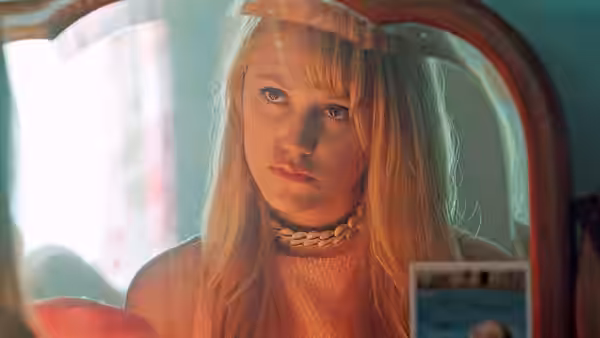 Jay Height (Maika Monroe) studying her reflection in a bathroom mirror