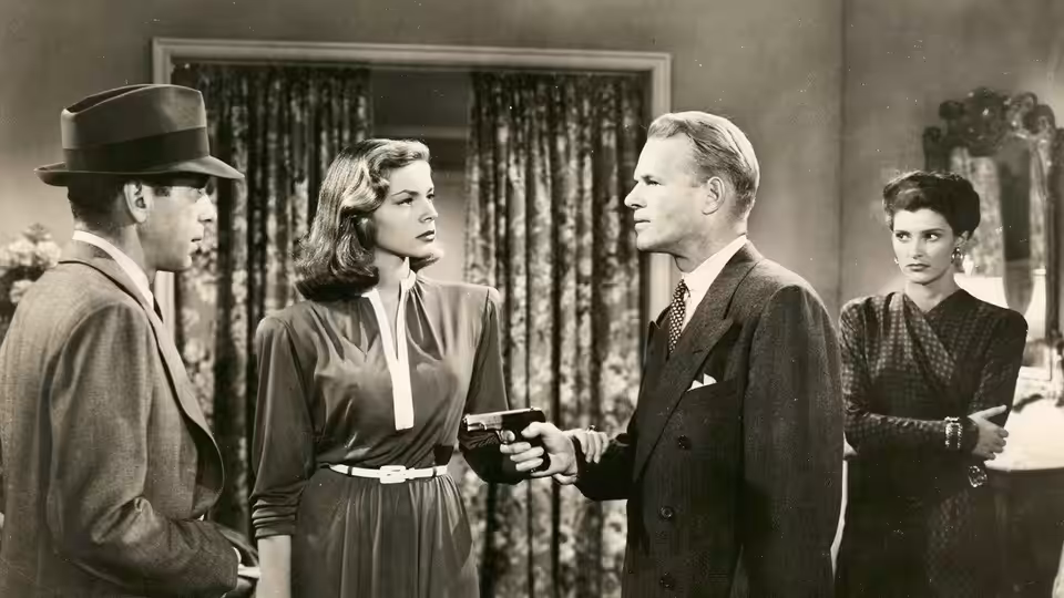 Philip Marlowe (Humphrey Bogart) faces a man pointing a gun as Vivian (Lauren Bacall) and a woman watch
