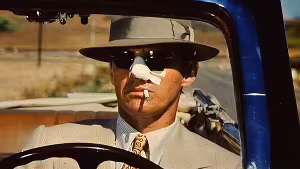 Jake Gittes (Jack Nicholson) with a cigarette in the driver's seat of a car