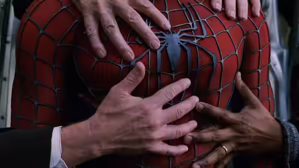 Several hands reach toward Spider-Man's torn suit as passengers discover his face beneath the mask