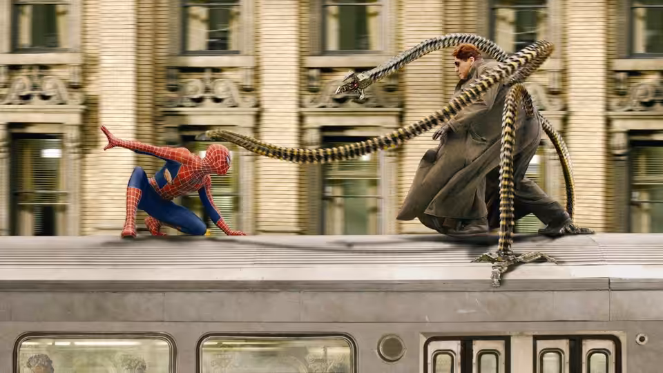 Spider-Man and Doc Ock battle atop a moving train as mechanical tentacles lash across the roof