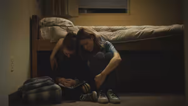 Grace (Brie Larson) and Jayden (Kaitlyn Dever) sitting on the floor reading a notebook
