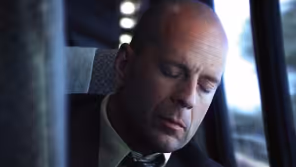 David Dunn (Bruce Willis) sits with eyes closed on a train