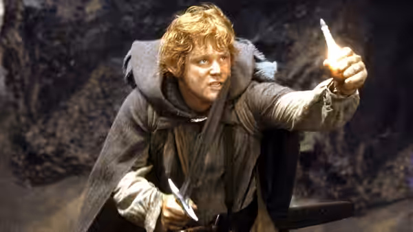 Merry (Dominic Monaghan) pointing upwards with a sword in hand