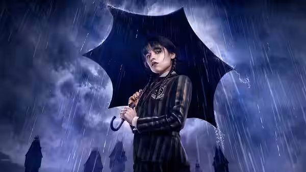 Wednesday (Jenna Ortega) standing under a black umbrella in heavy rain