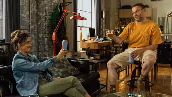 Sylvia (Rose Byrne) and Will (Seth Rogen) chatting with drinks in a loft