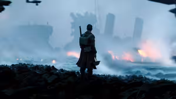 A soldier standing on the shore watching ships burn in the distance