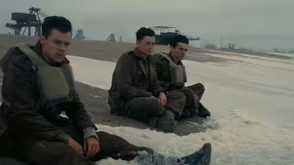 Three soldiers sitting on a frozen beach near the water