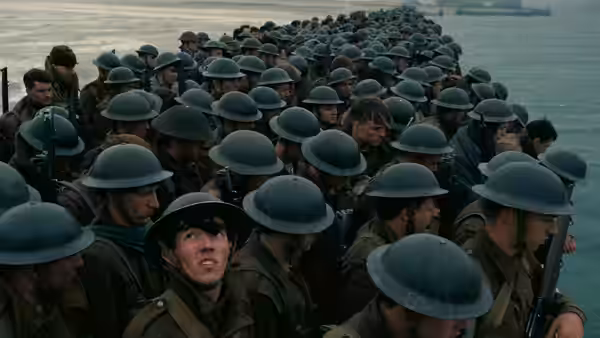 Soldiers in helmets crowded on a pier overlooking the sea