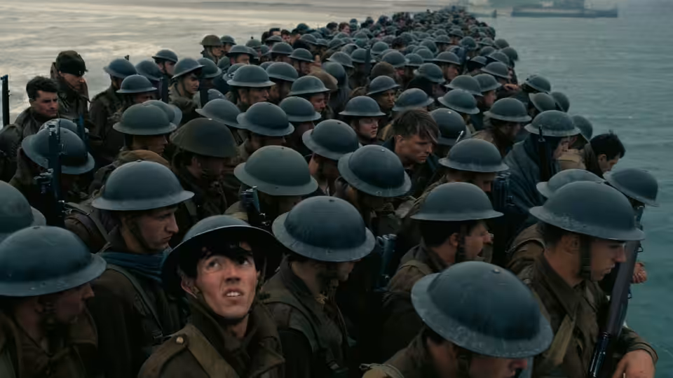 Soldiers in helmets crowded on a pier overlooking the sea