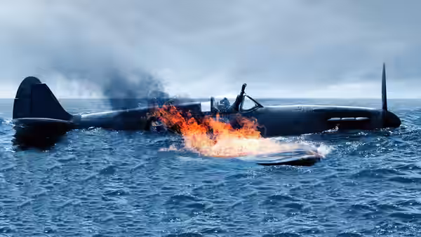 A burning fighter plane floating in the ocean with its pilot
