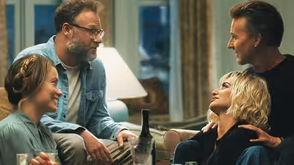 Four adults gathered on couches in a living room conversation