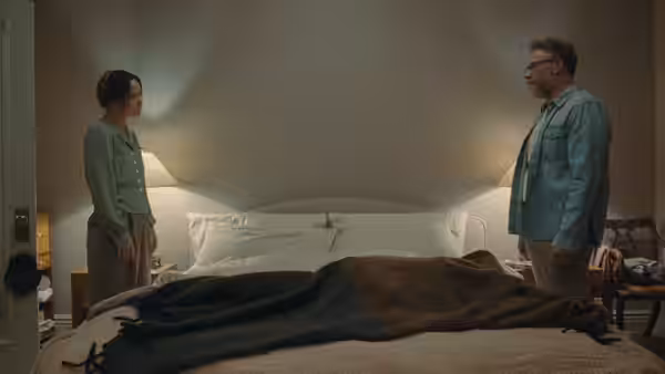 Woman and man standing opposite each other in a bedroom