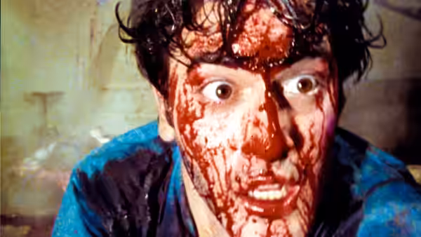 Ash (Bruce Campbell) stares ahead with blood covering his face