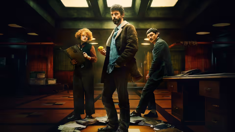 DCI Carl Morck (Matthew Goode) stands amid scattered papers in a police office
