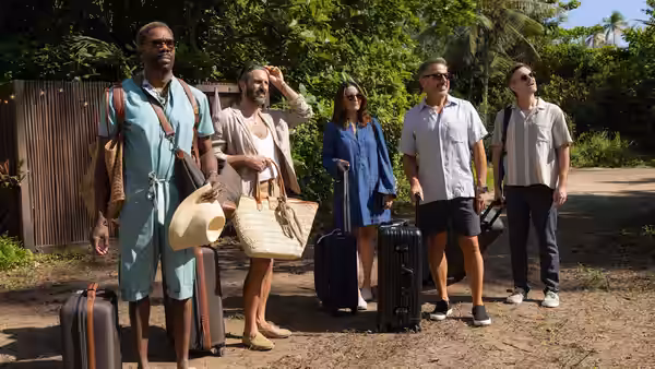 Colman Domingo and four companions with suitcases on a tropical dirt path