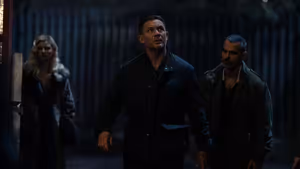 Harry Da Souza (Tom Hardy) striding forward at night with two others