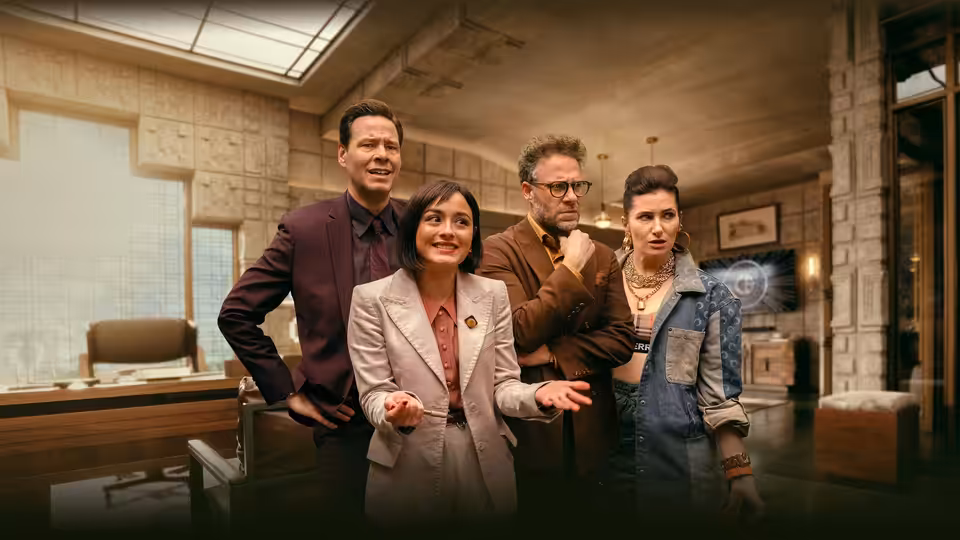 Seth Rogen as Matt Remick stands with three colleagues in a large office