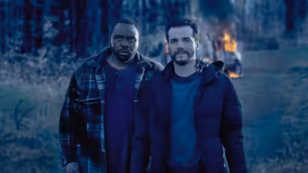 Ray Driscoll (Brian Tyree Henry) and Manny Carvalho (Wagner Moura) standing in a forest at night