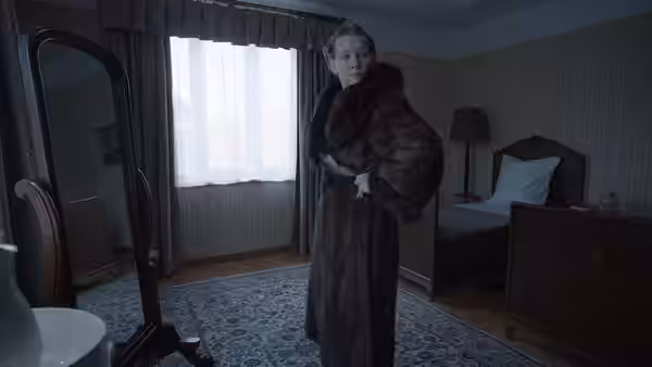 Hedwig Höss (Sandra Hüller) adjusts fur coat in bedroom