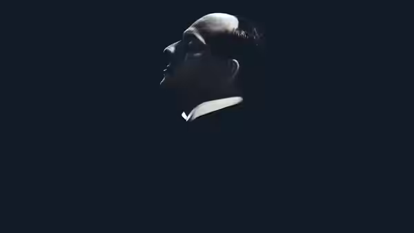 Mussolini (Luca Marinelli) shown in profile against a dark background