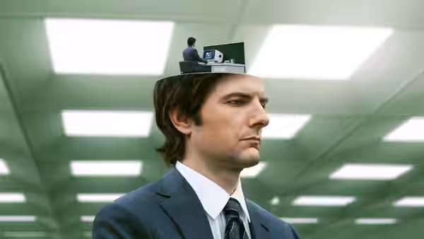 Mark Scout (Adam Scott) with a miniature office atop his head