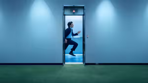 Mark Scout (Adam Scott) leaping from an elevator into a blue hallway