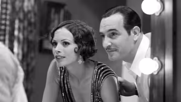 George Valentin (Jean Dujardin) and Peppy Miller (Bérénice Bejo) peering from dressing room doorway