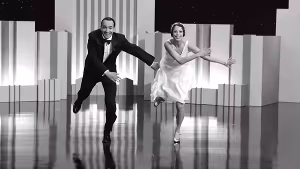 George Valentin (Jean Dujardin) and Peppy Miller (Bérénice Bejo) dancing energetically on reflective stage floor