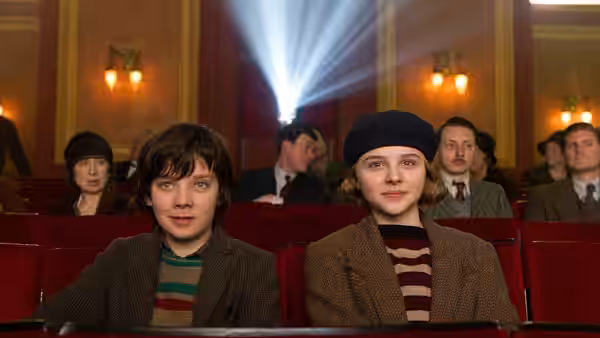 Hugo Cabret (Asa Butterfield) and Isabelle (Chloë Grace Moretz) seated in a cinema