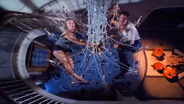Oliver Rose (Michael Douglas) and Barbara Rose (Kathleen Turner) cling to a chandelier above the foyer
