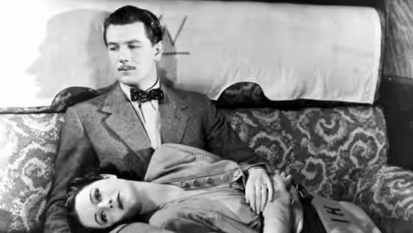 Iris (Margaret Lockwood) rests her head on Gilbert (Michael Redgrave) in a train compartment