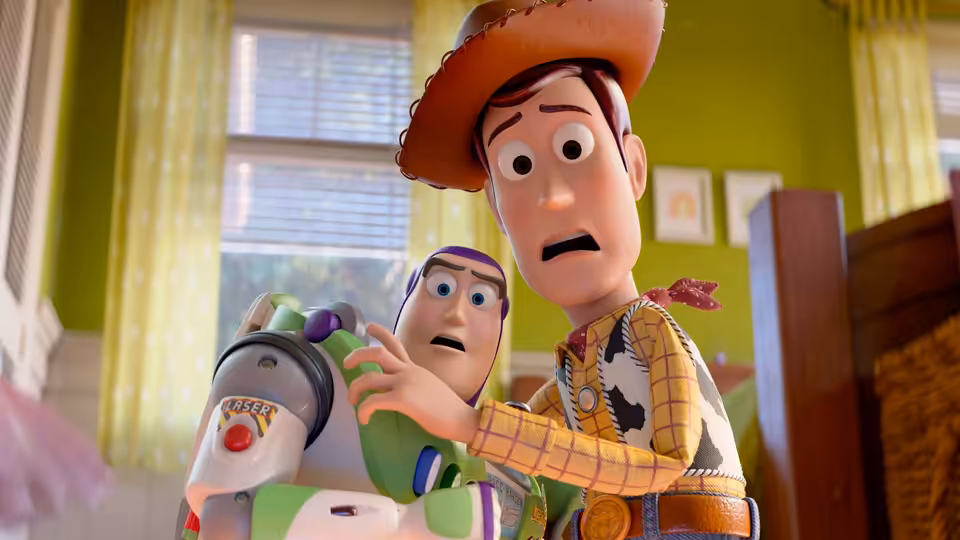 Woody and Buzz Lightyear stand in a bedroom with surprised expressions