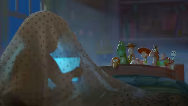 Toys peek from under a polka dot blanket on a wooden bed