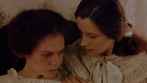 A woman comforts a distressed young woman in a pale dress