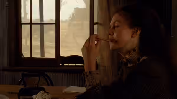 Sybylla Melvyn (Judy Davis) smokes by a window overlooking the countryside