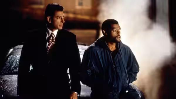 Russell Stevens Jr. (Laurence Fishburne) and David Jason (Jeff Goldblum) stand beside a car