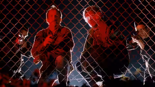 David Jason (Jeff Goldblum) and Russell Stevens Jr. (Laurence Fishburne) stand behind a chain-link fence