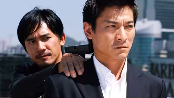 Tony Leung with a gun held against his shoulder by another man outdoors