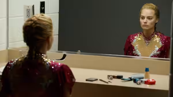Tonya (Margot Robbie) studies her reflection in a dressing-room mirror, wearing her skating costume