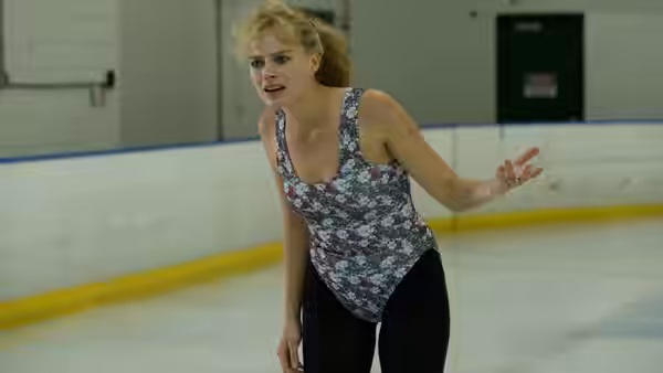 Tonya (Margot Robbie) gestures while practicing on the ice in a floral skating outfit