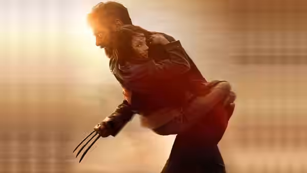 Logan (Hugh Jackman) carrying Laura (Dafne Keen) with claws extended