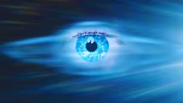 A luminous blue eye radiates light against a dark background