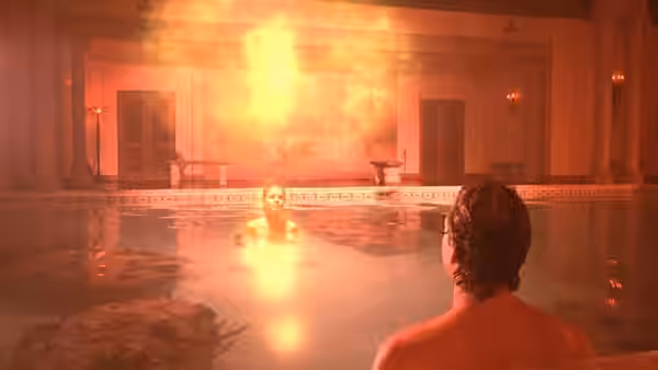 A man watches a woman glowing in the water of an indoor pool