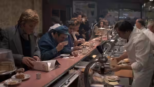 Joseph Turner (Robert Redford) reading a newspaper at a crowded lunch counter