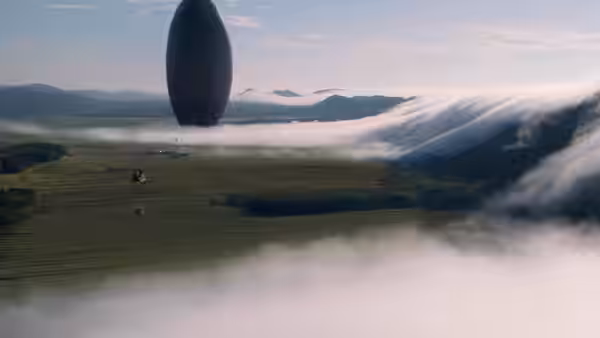 A dark oval vessel floats above misty mountains over green countryside