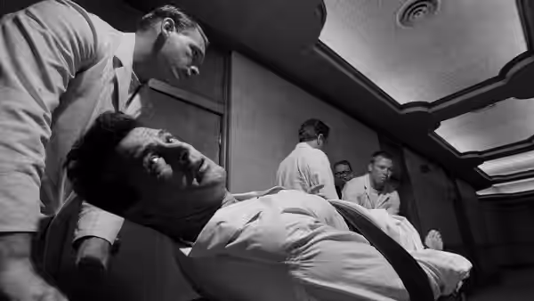 A man lies on a gurney as medical staff prepare him for surgery
